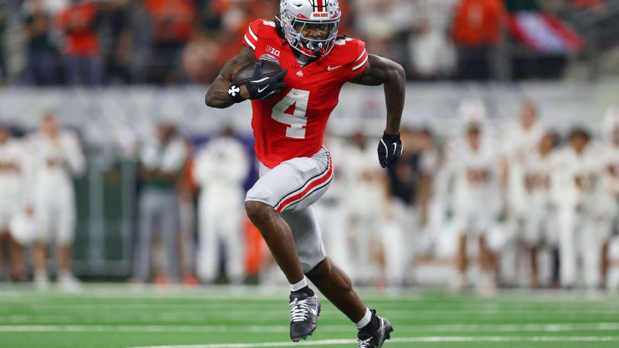 FILE - Ohio State wide receiver Jeremiah Smith runs the ball against Miami during the second half of the Cotton Bowl College Football Playoff quarterfinal game, Dec. 31, 2025, in Arlington, Texas.