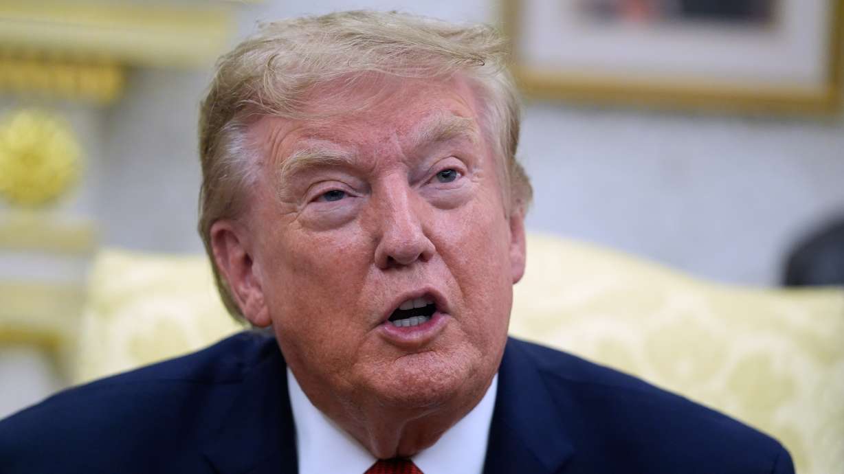 President Donald Trump speaks as he meets with lifeguard Ryder Williams in the Oval Office of the White House, Monday, in Washington. The Trump administration said Monday it is temporarily pausing construction of a contentious border construction project in Texas' Big Bend National Park.