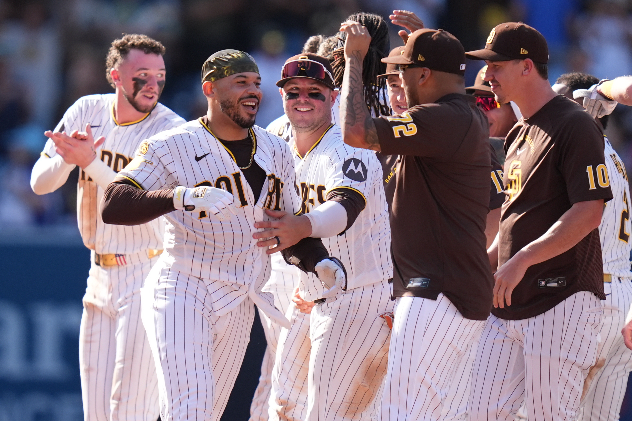 San Diego Padres' Luis Campusano, second from left, celebrates with teammates after hitting a walk off single to defeat the Brewers during the eleventh inning of a baseball game Wednesday, Aug. 12, 2026, in San Diego. 