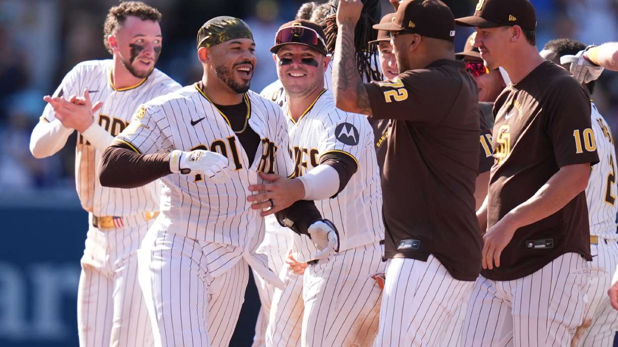 San Diego Padres' Luis Campusano, second from left, celebrates with teammates after hitting a walk off single to defeat the Brewers during the eleventh inning of a baseball game Wednesday, Aug. 12, 2026, in San Diego.