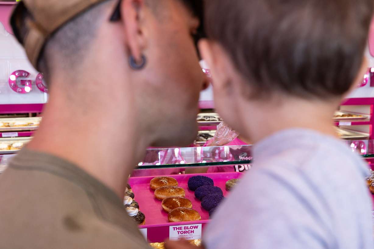 A father and son browse doughnuts together at the new Pinkbox Doughnuts located at 10235 State St. in Sandy on Sunday.