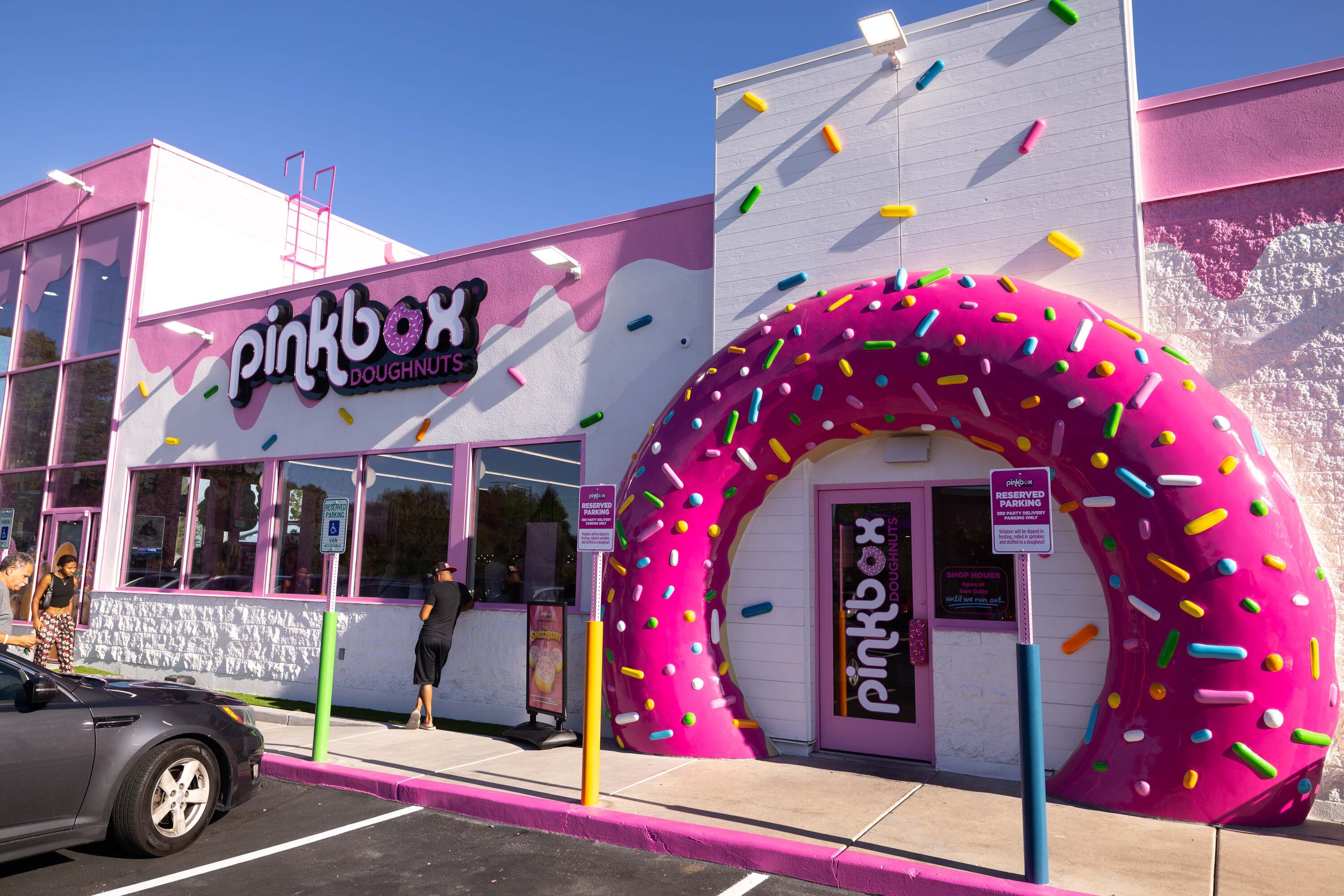 Customers arrive at the new Pinkbox Doughnuts located at 10235 State St. in Sandy on Sunday.