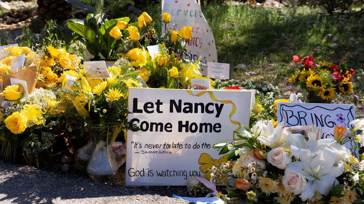 A sign stands amid yellow flowers left at the house of Nancy Guthrie, the 84-year-old mother of U.S. journalist and television host Savannah Guthrie, who went missing from her home on Feb. 1, in Tucson, U.S., Feb. 21.