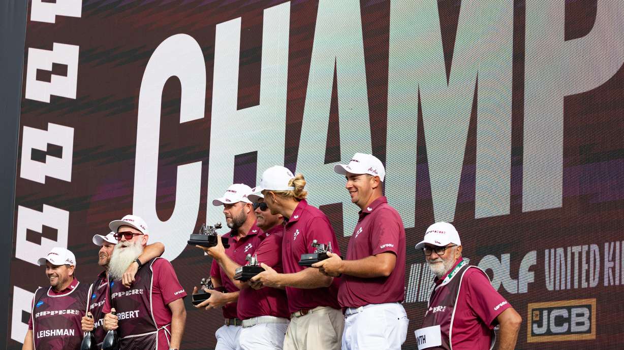 Team champions captain Cameron Smith, Marc Leishman, Lucas Herbert and Travis Smyth, of Ripper GC, and their caddies celebrate onstage after their first-place win following the final round of the LIV Golf United Kingdom golf tournament Sunday, July 26, 2026, in Rocester, England.
