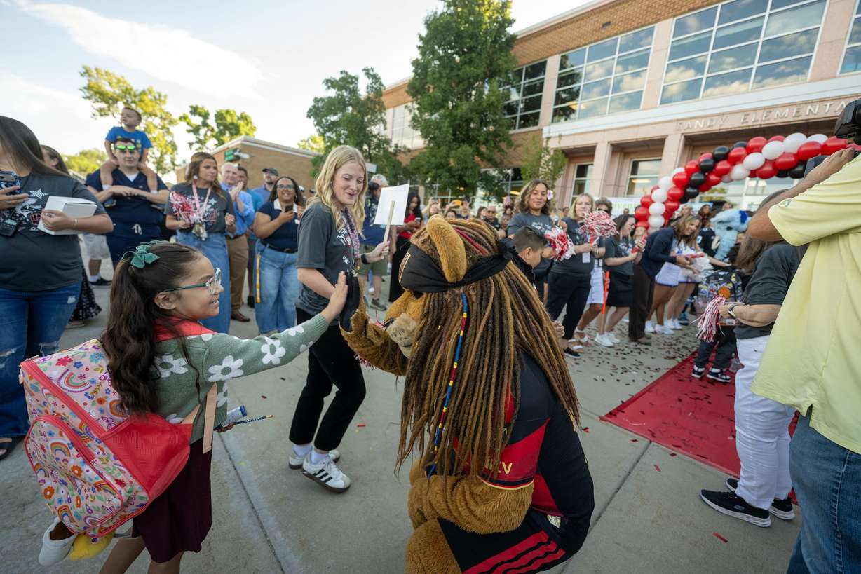 Real Salt Lake’s Leo the Lion high-fives students as they enter the school as Sandy Elementary welcomes its students back to school with a celebratory atmosphere and a red-carpet walk on Monday.