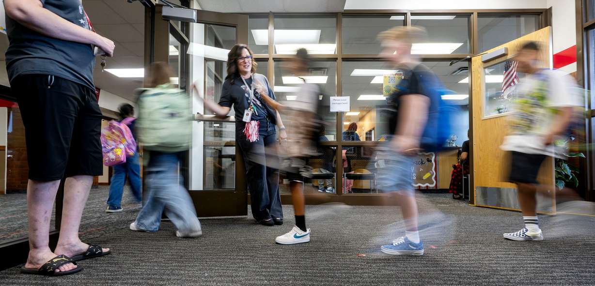 Isa Connlelly, a community school facilitator, greets the kids as Sandy Elementary welcomes its students back to school with a celebratory atmosphere and a red-carpet walk on Monday.