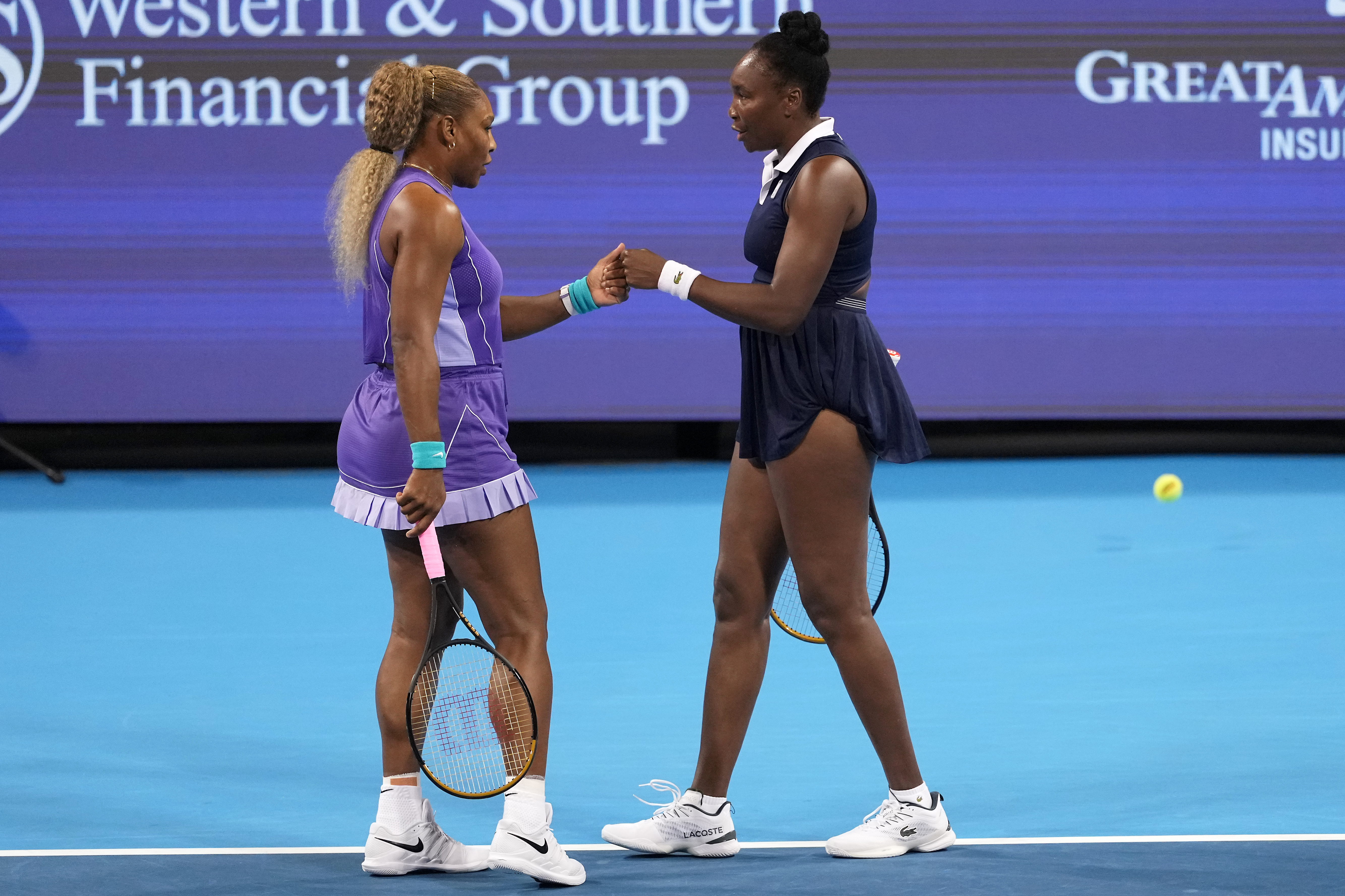 Serena Williams, left, first bumps Venus Williams, right, both of the United States, during a women's doubles match against Marta Kostyuk, of Ukraine, and Peyton Stearns, also of the United States, at the Cincinnati Open tennis tournament, Monday, Aug. 17, 2026, in Mason, Ohio. 