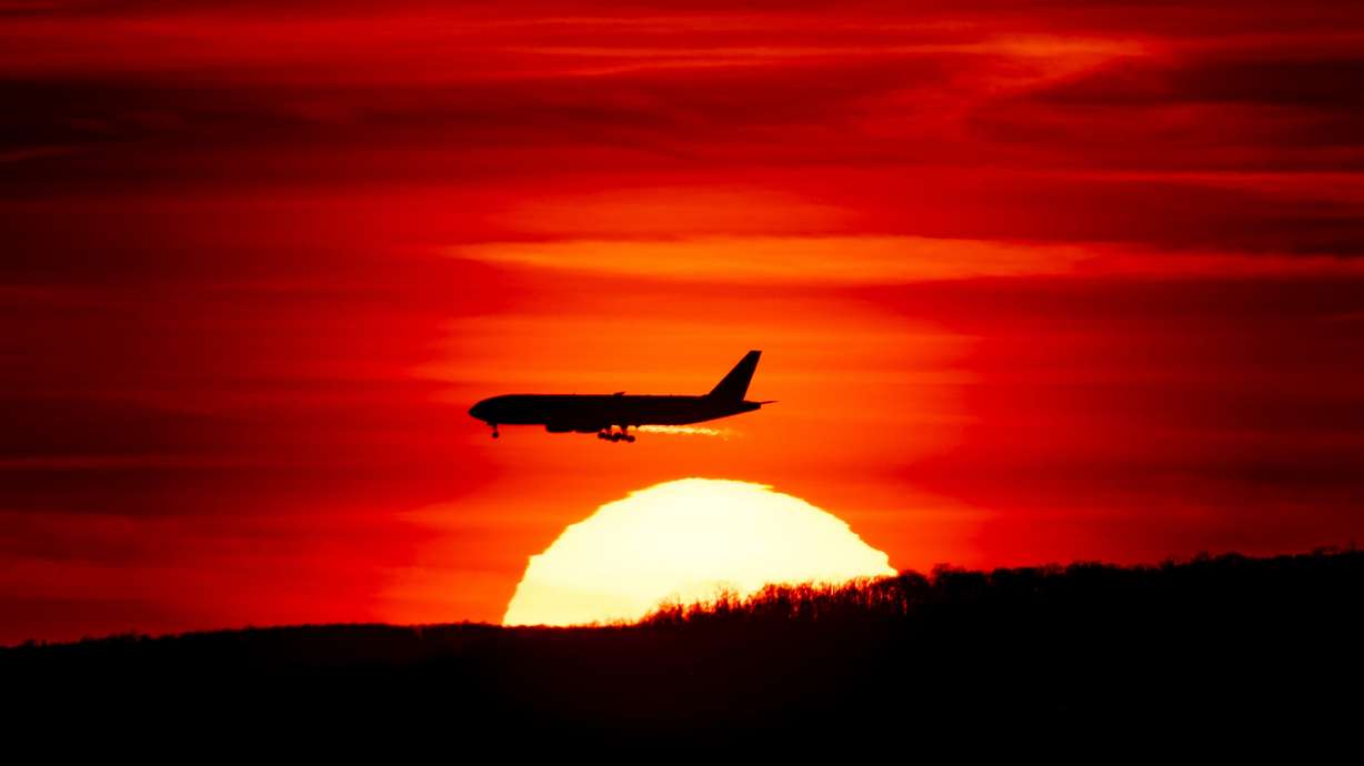 A passenger jet on approach to Newark Liberty International Airport flies over the setting sun in Newark, N.J., March 27, 2019. Flight attendants and pilots are at the highest risk of dying from radiation-related cancers, a new study says.