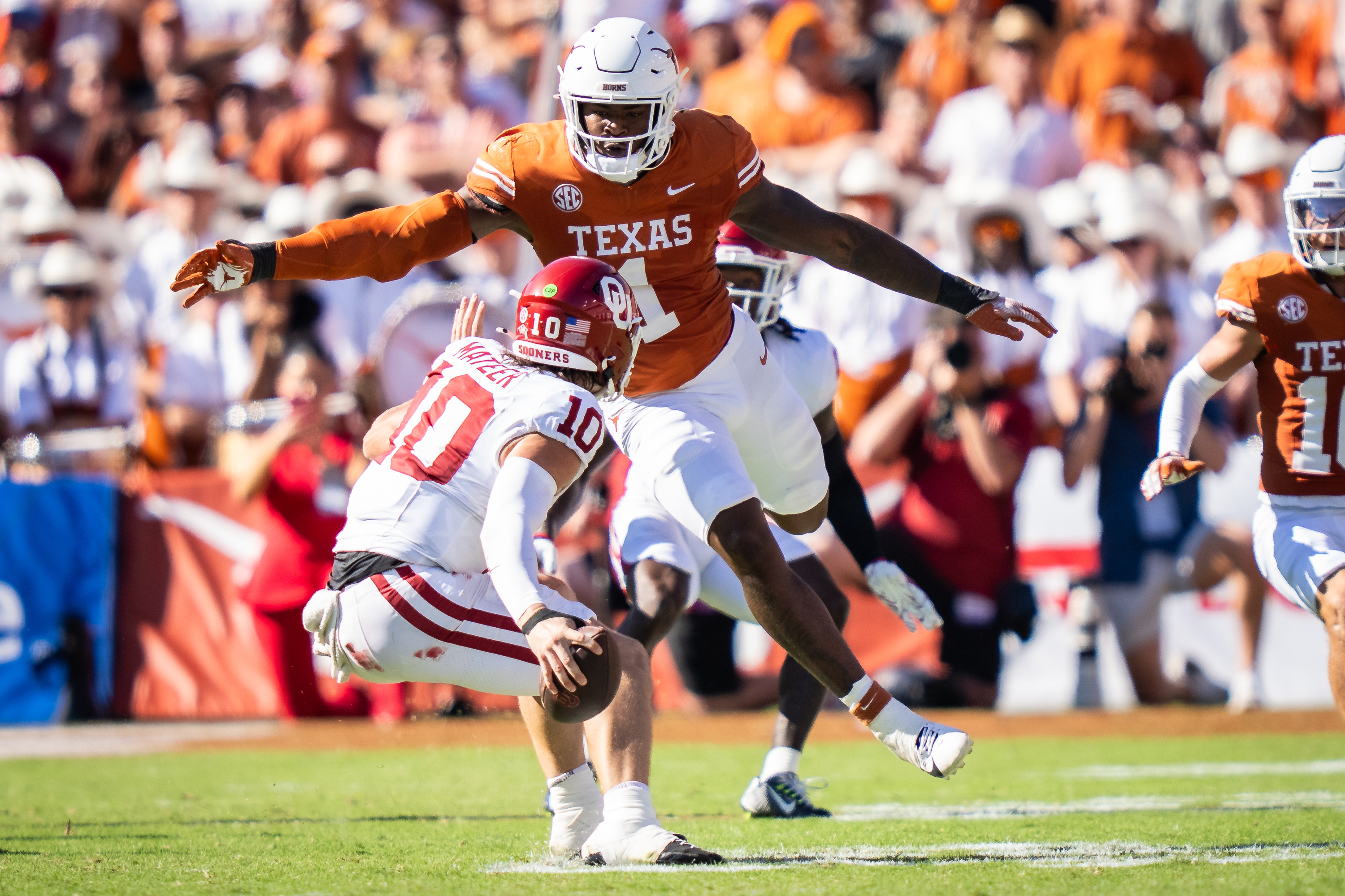 FILE - Texas linebacker Colin Simmons (1) goes to tackle Oklahoma Sooners quarterback John Mateer (10) during the second quarter of an NCAA college football game at the Cotton Bowl in Dallas, Oct. 11, 2025. 