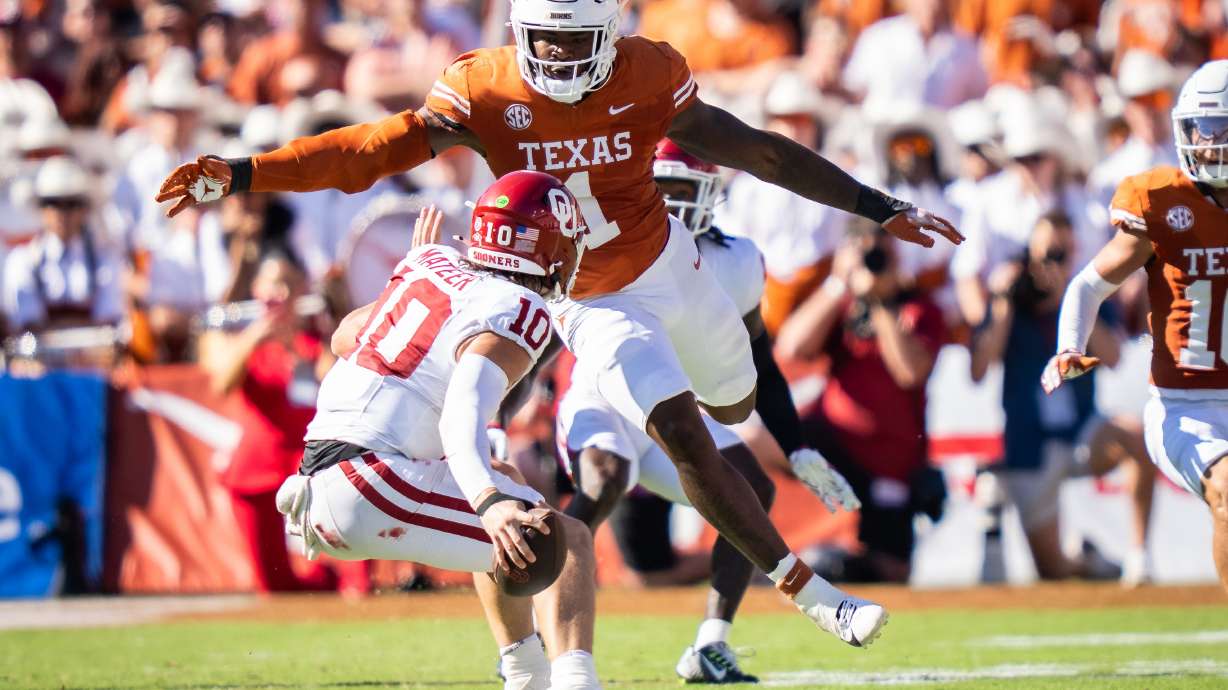 FILE - Texas linebacker Colin Simmons (1) goes to tackle Oklahoma Sooners quarterback John Mateer (10) during the second quarter of an NCAA college football game at the Cotton Bowl in Dallas, Oct. 11, 2025.