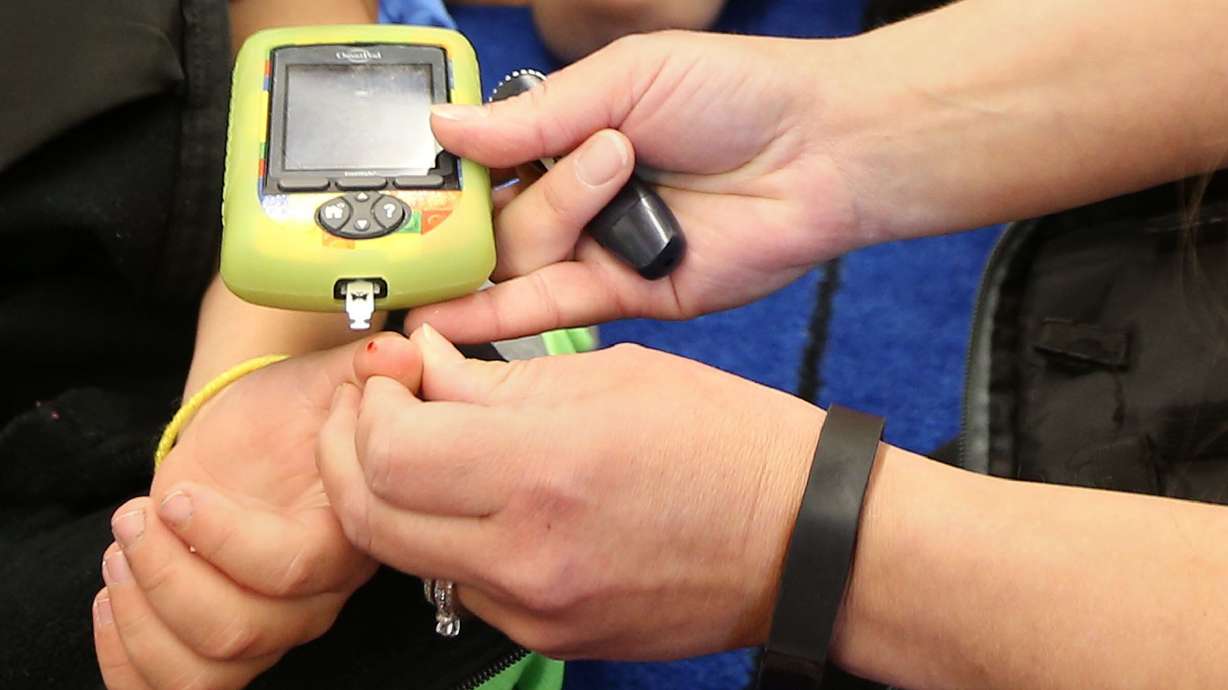 A school nurse checks the blood sugar of a first-grader who has Type 1 diabetes, at Trailside Elementary School in Park City on Sept. 26, 2016.