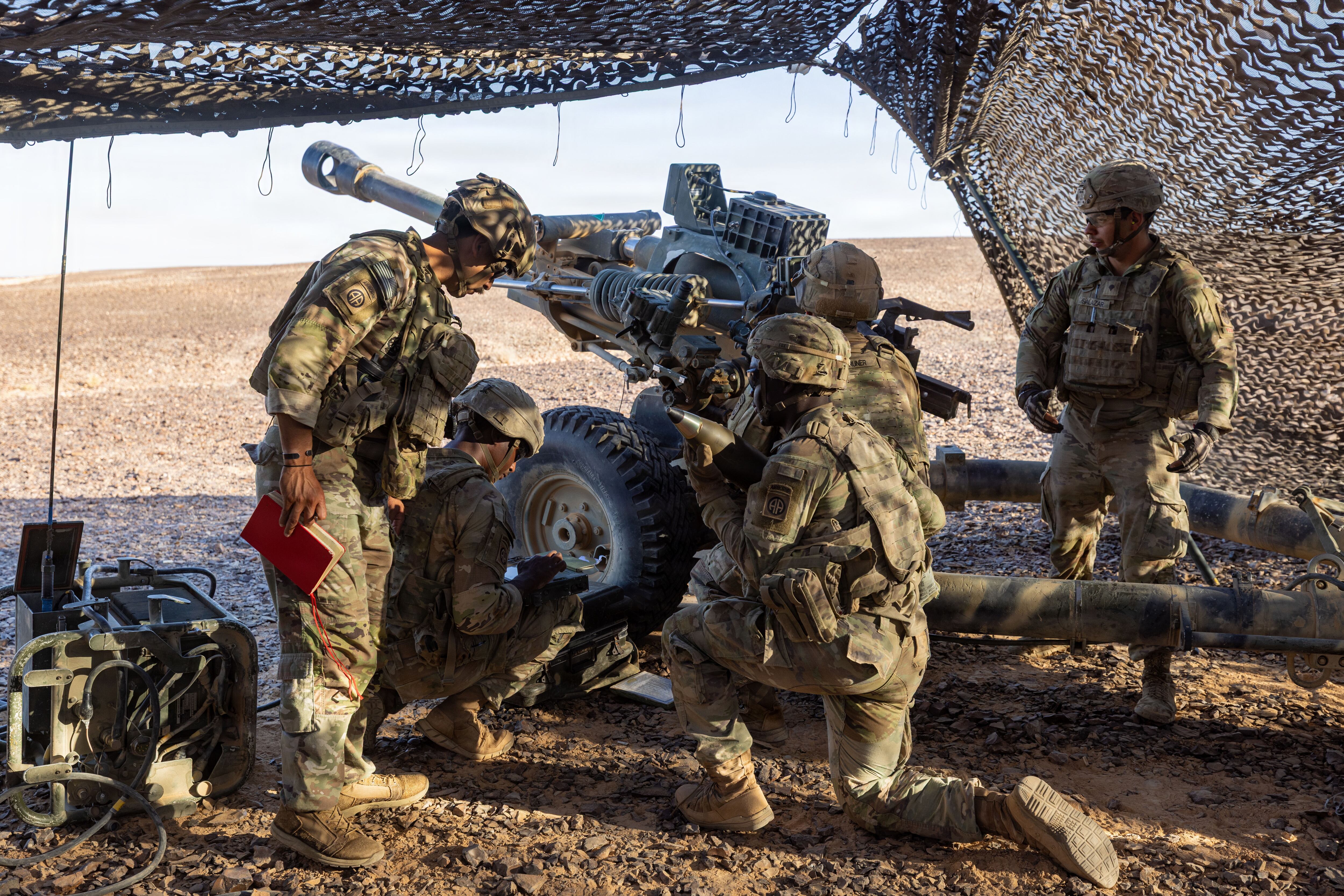 U.S. Army paratroopers prepare a howitzer for a fire mission during a field artillery live-fire exercise in the Middle East. The exercise validated capabilities, demonstrating the synchronized lethality required to systematically target and degrade adversaries in multi-domain combat operations.