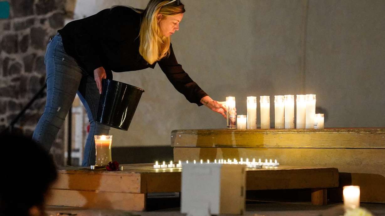 A woman places a candle during a candlelight vigil Aug. 4, in Twin Falls, Idaho, to honor the victims of a recent shooting at a local In-N-Out Burger. While personal protection is the leading reason for Americans owning guns, it doesn't necessarily make surrounding people feel safer.