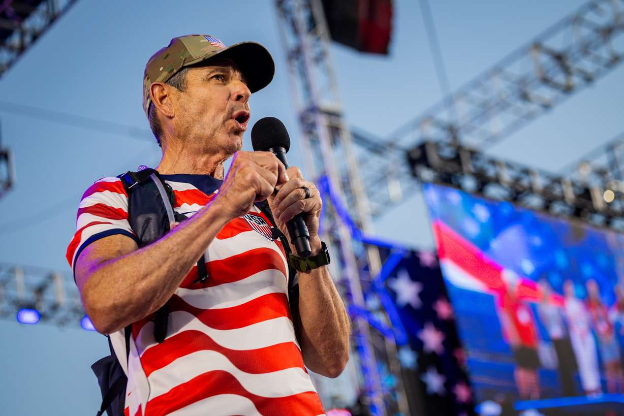 Sen. John Curtis, R-Utah, right, speaks to attendees after ending his America 250 walk from Bear Lake to Stadium of Fire at LaVell Edwards Stadium in Provo on America’s 250th anniversary on July 4, 2026. A recent survey shows his approval rating is down along with other Utah politicians.