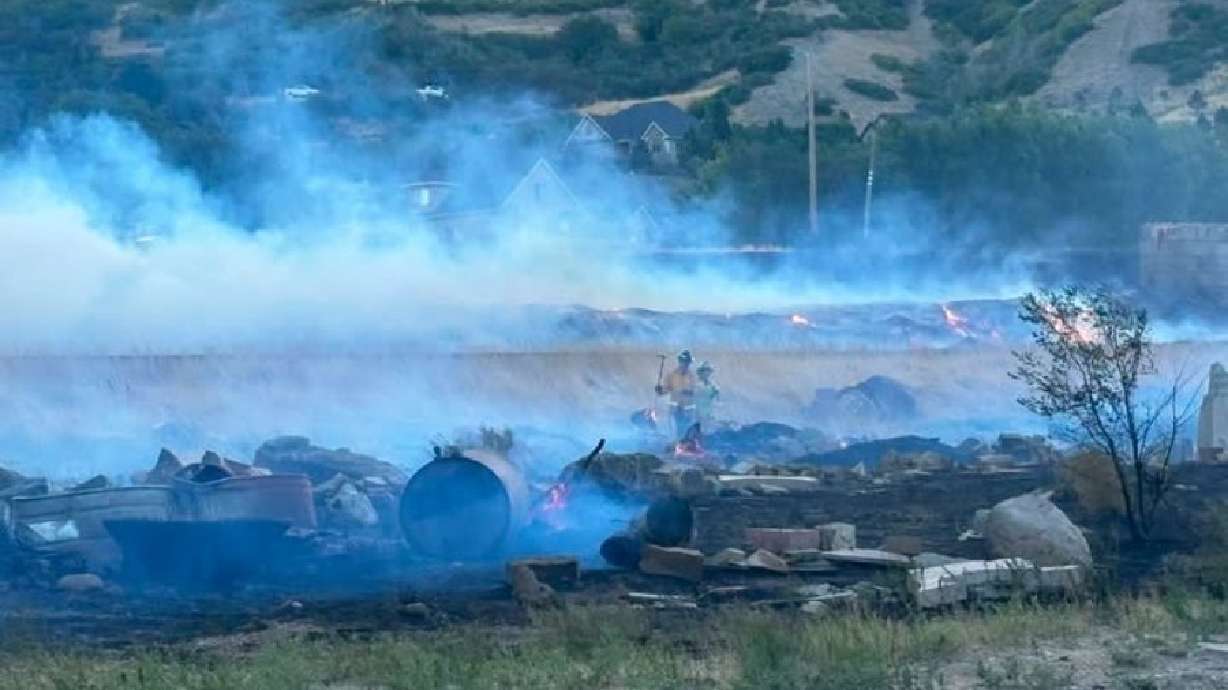 Fire crews work on extinguishing piles of debris burning at the Dugway Fire in Weber County on Wednesday.