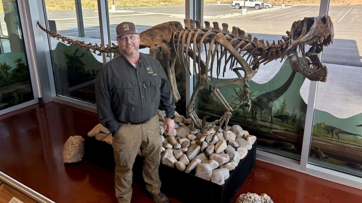 Brad Walker, manager at Utahraptor State Park, poses with a replica skeleton of the park's namesake in September 2025. The new state park experienced a major jump in visitation over the past fiscal year.