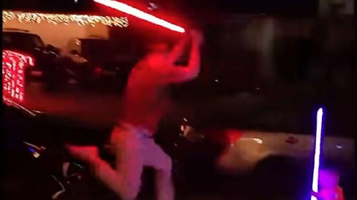 A father and son have an epic light saber battle in Los Angeles on Dec. 22, 2025.