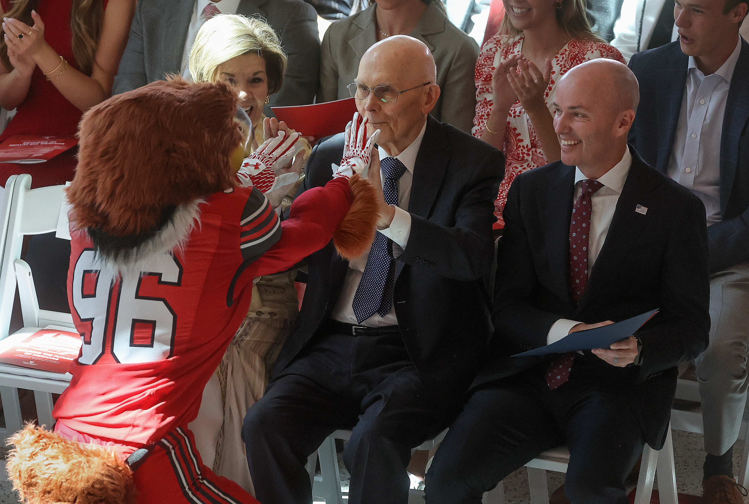 Swoop high-fives President Dallin H. Oaks, of The Church of Jesus Christ of Latter-day Saints, during the dedication ceremony for the new Spencer Fox Eccles School of Medicine at the University of Utah in Salt Lake City on Wednesday.