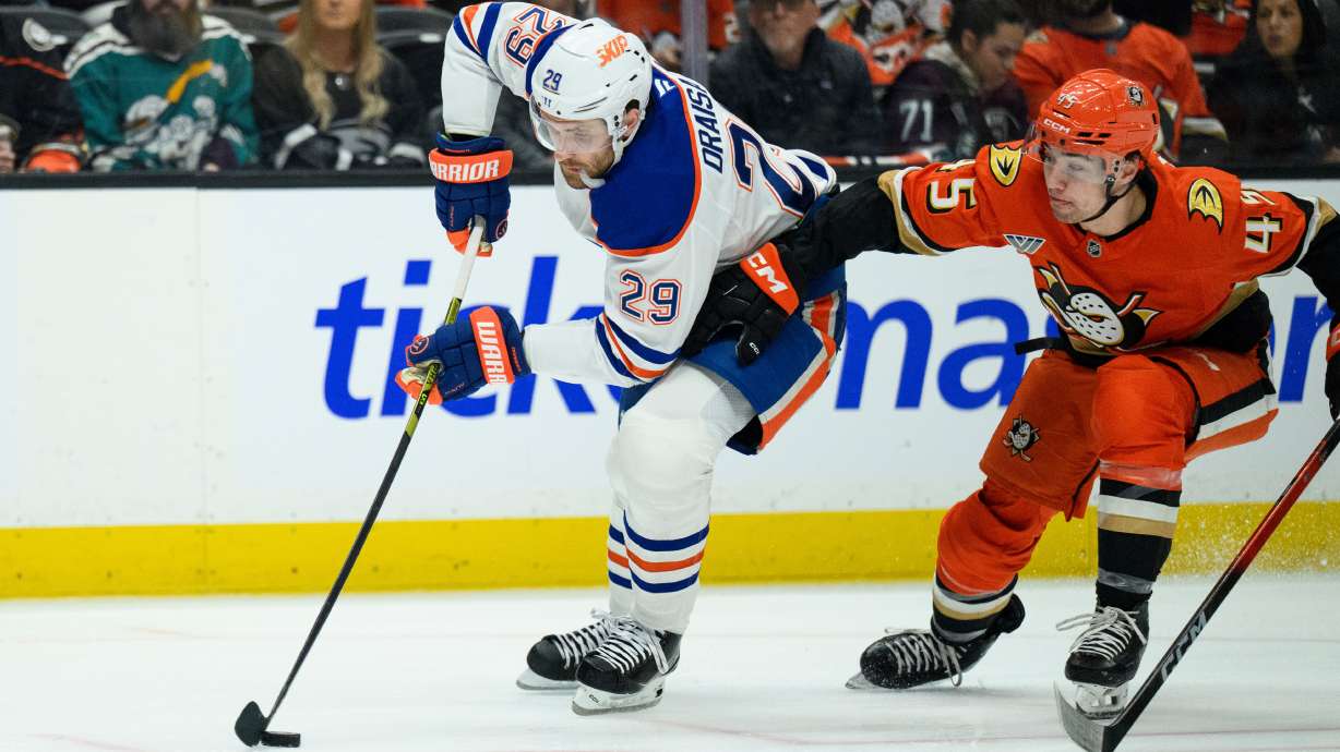 FILE - Edmonton Oilers center Leon Draisaitl, left, controls the puck as Anaheim Ducks right wing Beckett Sennecke defends during the second period of Game 4 in the first round of an NHL hockey Stanley Cup playoff series Sunday, April 26, 2026, in Anaheim, Calif. , File)