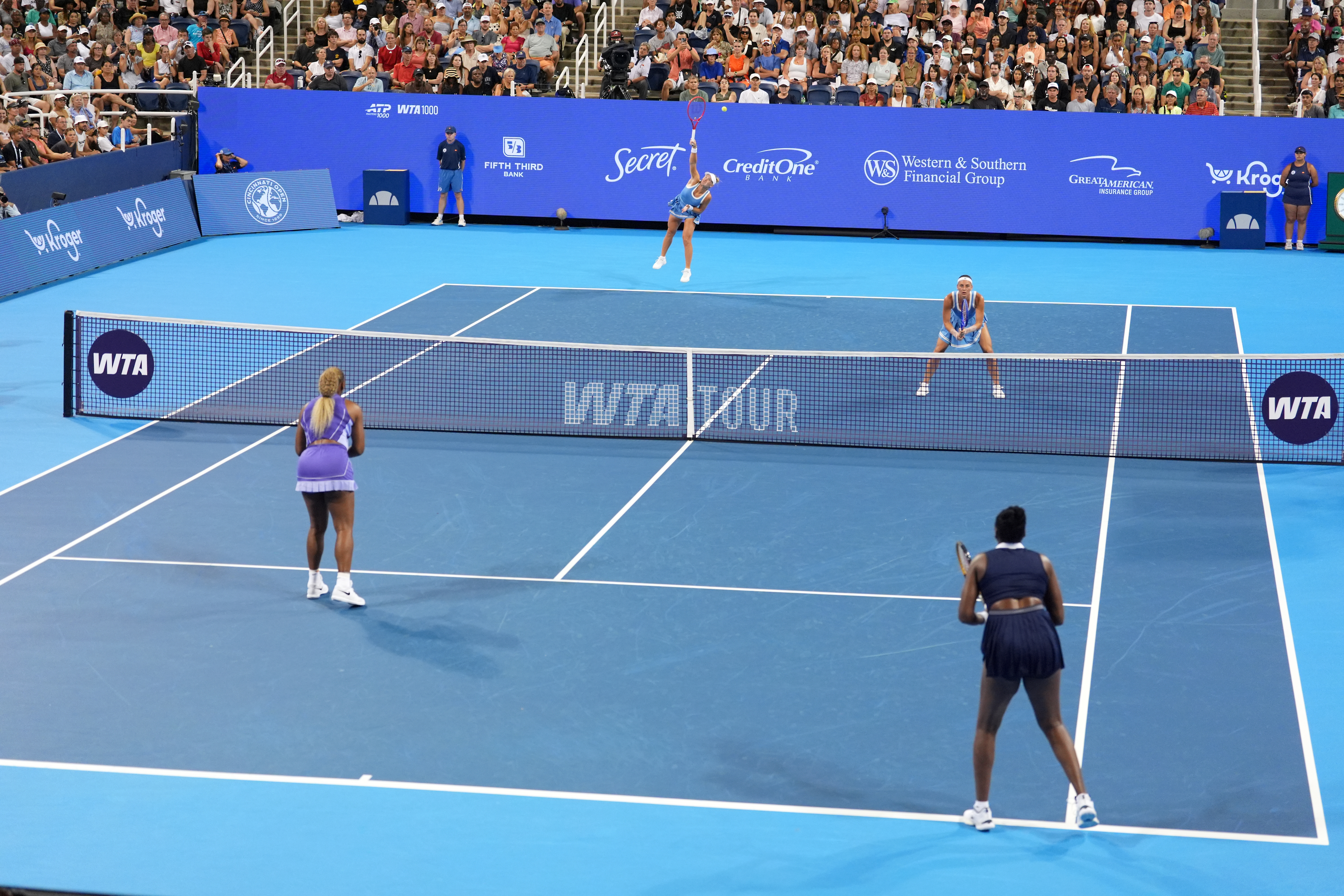 As Peyton Stearns, top right, of the United States, looks on, Marta Kostyuk, top center, of Ukraine, serves against Serena Williams, bottom left, and Venus Williams, bottom right, also of the United States, during a women's doubles match at the Cincinnati Open tennis tournament, Monday, Aug. 17, 2026, in Mason, Ohio. 