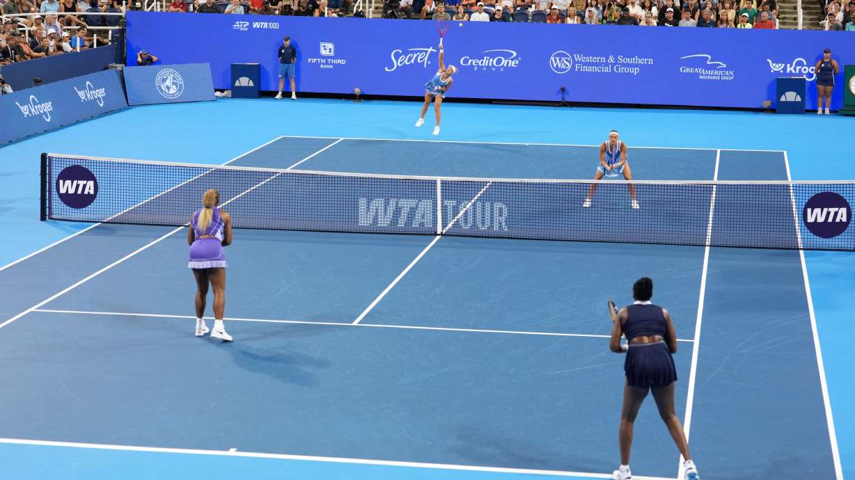 As Peyton Stearns, top right, of the United States, looks on, Marta Kostyuk, top center, of Ukraine, serves against Serena Williams, bottom left, and Venus Williams, bottom right, also of the United States, during a women's doubles match at the Cincinnati Open tennis tournament, Monday, Aug. 17, 2026, in Mason, Ohio.