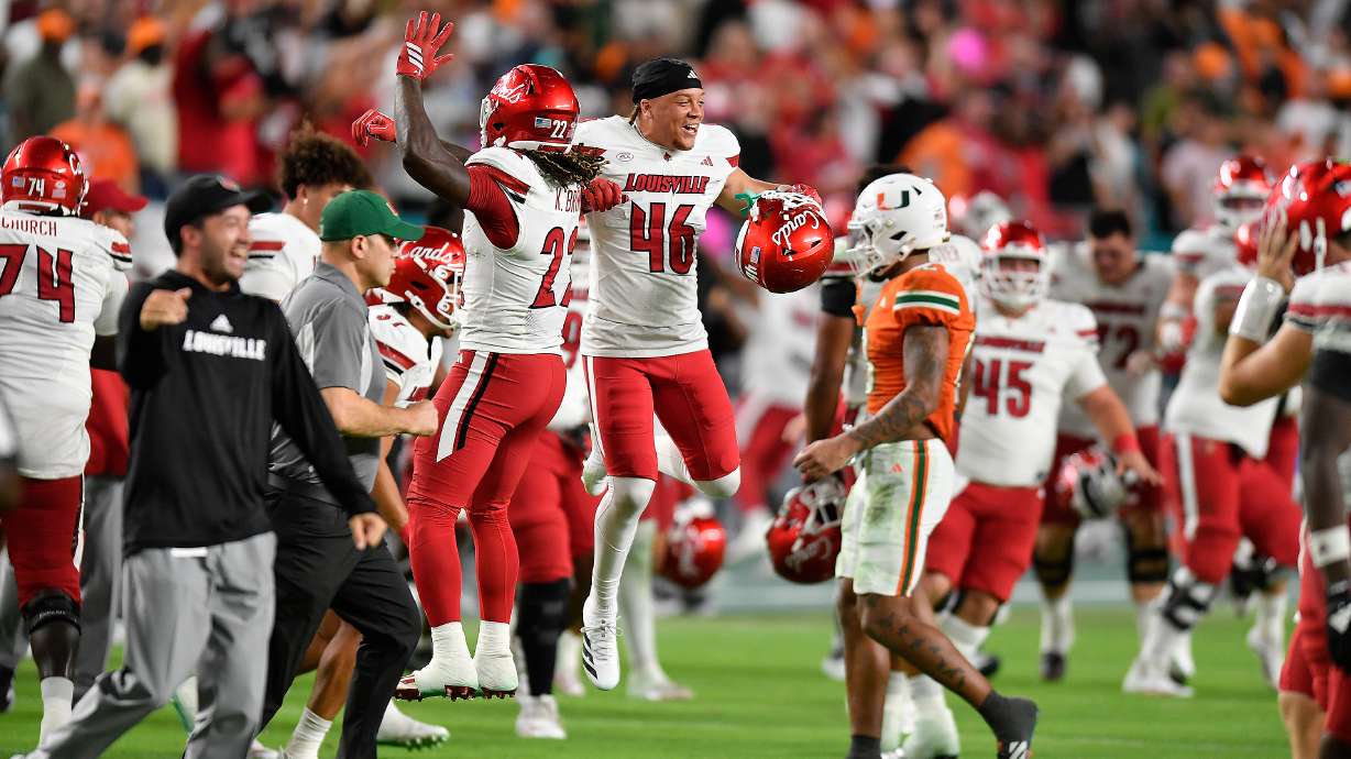 FILE - Louisville players celebrate beating Miami in an NCAA college football game, Oct. 17, 2025, in Miami Gardens, Fla.