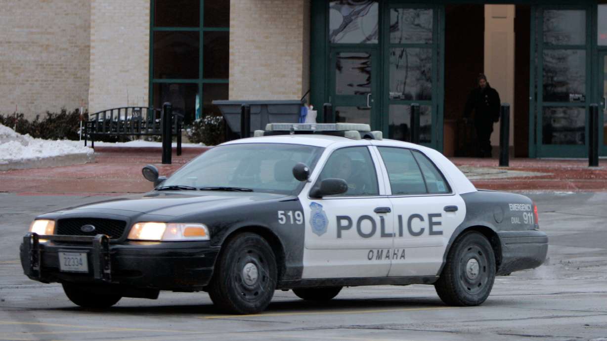 An Omaha police car drives on Dec. 8, 2007, in Omaha, Neb. Omaha police agreed this week to stop carrying gloves that can deliver electric shocks to students in the halls of Nebraska's largest public school district.