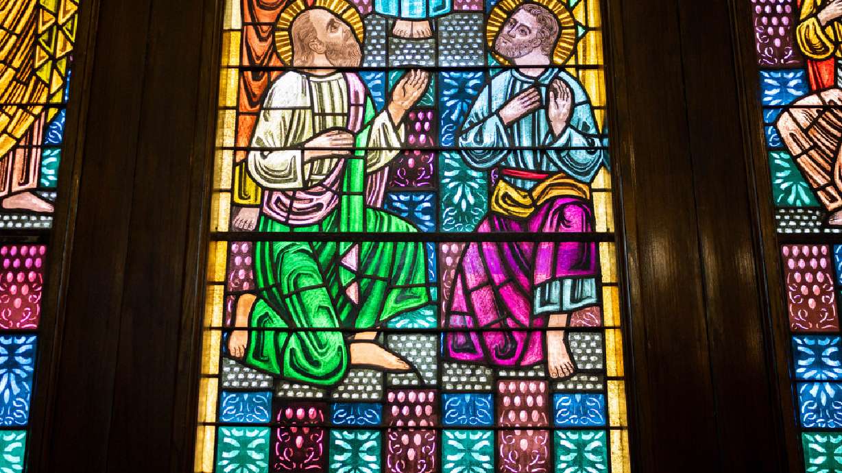 Stained-glass windows show religious scenes, backlit by sunlight, inside the Holy Trinity Cathedral of the Greek Orthodox Church in Salt Lake City on Aug. 18.