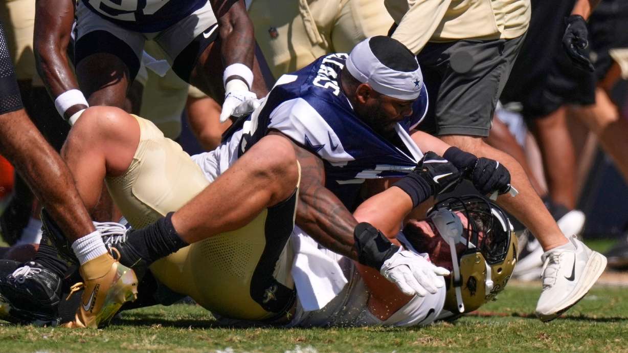 Dallas Cowboys outside linebacker Sam Williams, top, fight with New Orleans Saints tight end Moliki Matavao during an NFL football joint practice, Tuesday, Aug. 18, 2026, in Oxnard, Calif.