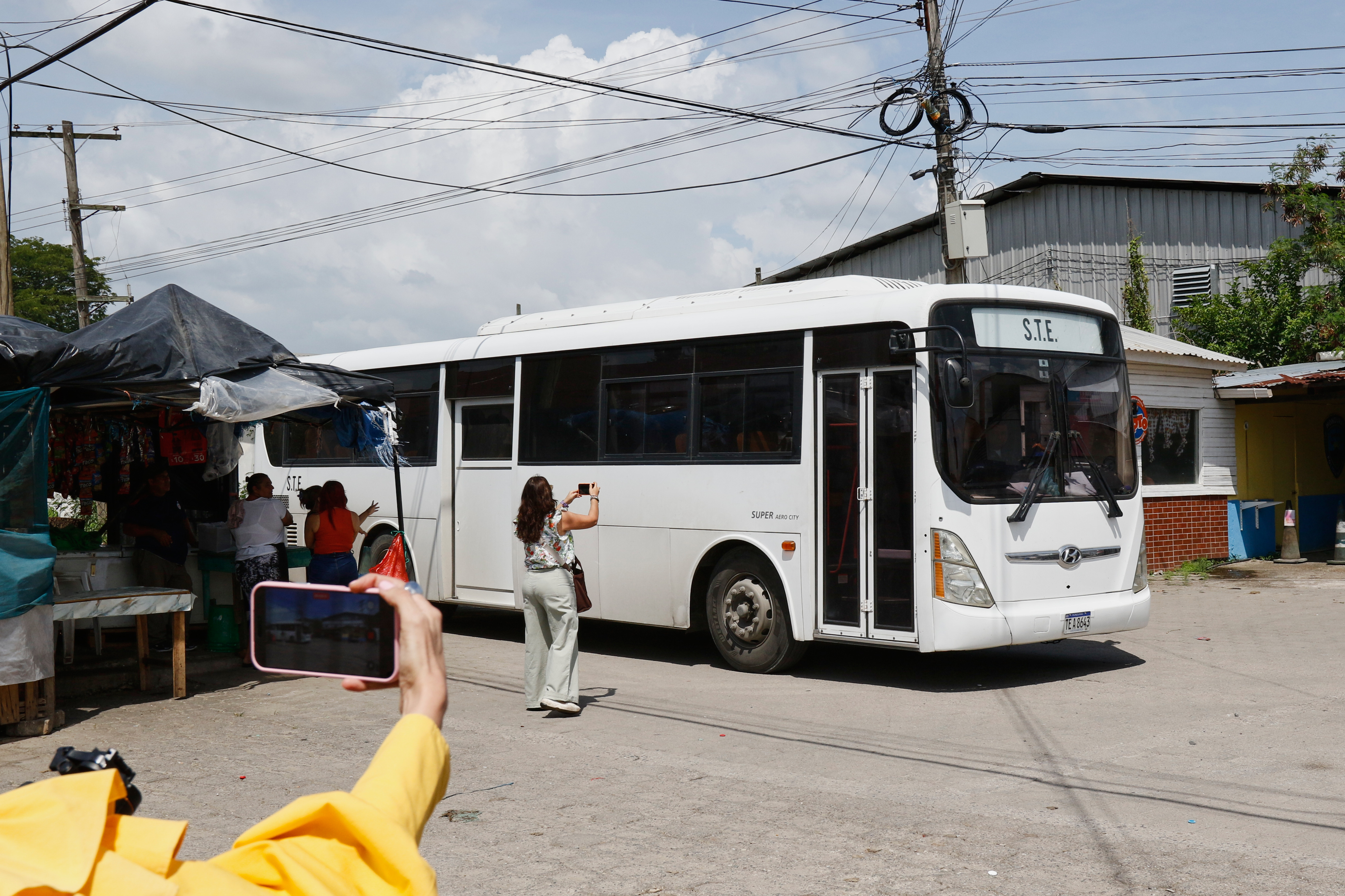Journalists take images of a bus transporting migrants deported from the United States following their arrival at the Ramón Villeda Morales Airport in San Pedro Sula, Honduras, on Thursday.