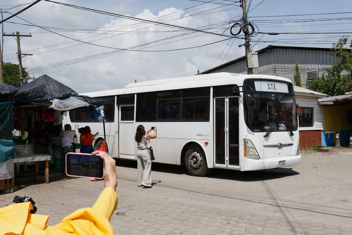 Journalists take images of a bus transporting migrants deported from the United States following their arrival at the Ramón Villeda Morales Airport in San Pedro Sula, Honduras, on Thursday.