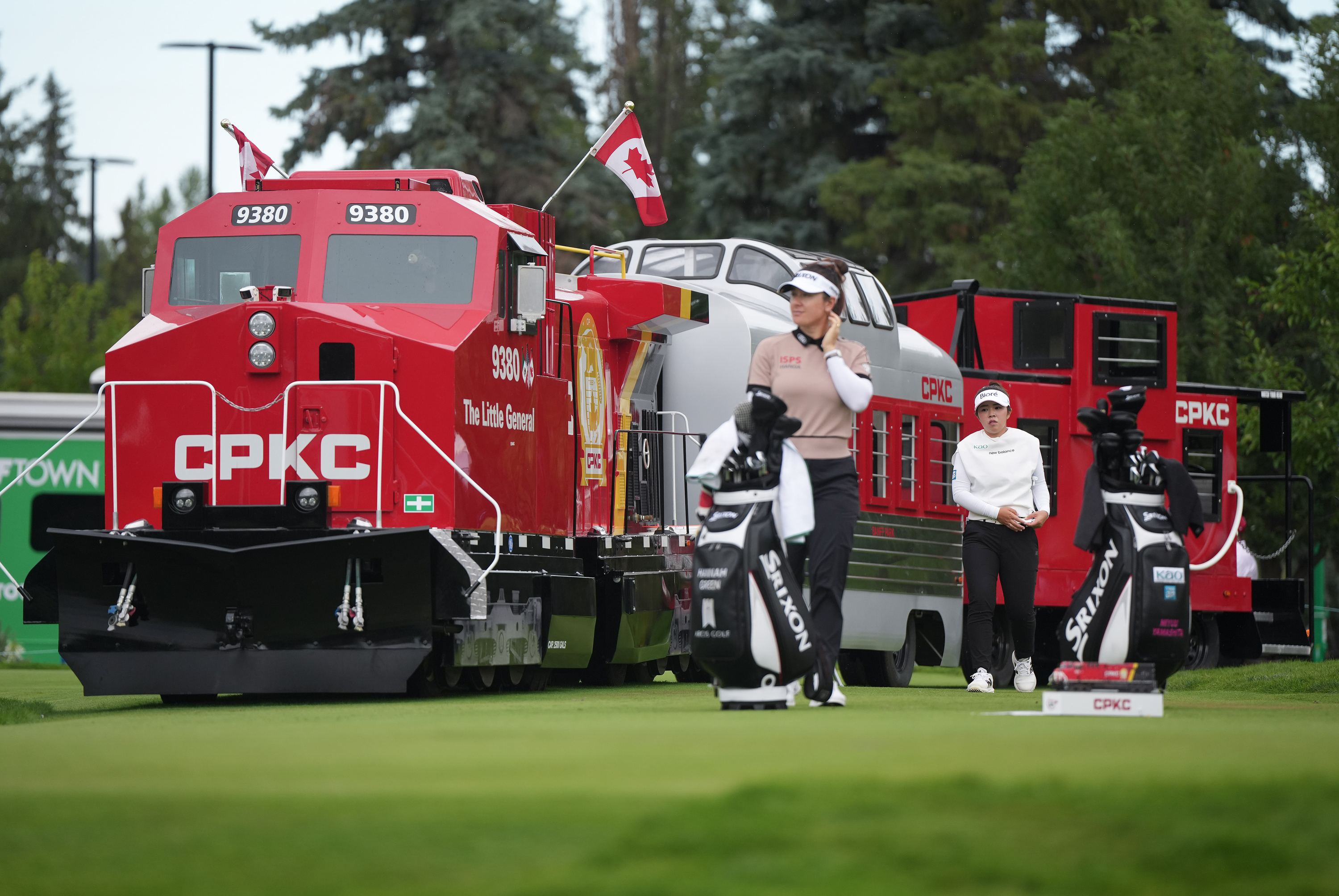 Miyu Yamashita, back right, of Japan, walks past a mini CPKC train as she arrives at the first tee behind Hannah Green, of Australia, during the first round at the LPGA Canadian Women's Open golf tournament in Edmonton, Alberta, Thursday, Aug. 20, 2026. 