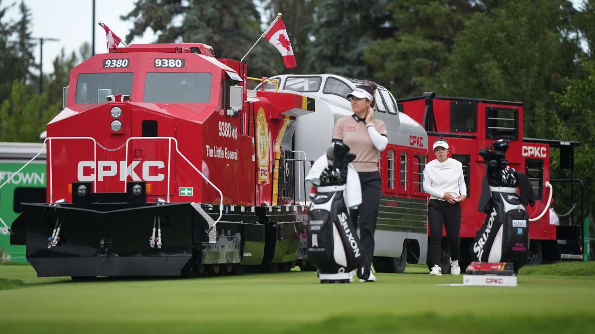 Miyu Yamashita, back right, of Japan, walks past a mini CPKC train as she arrives at the first tee behind Hannah Green, of Australia, during the first round at the LPGA Canadian Women's Open golf tournament in Edmonton, Alberta, Thursday, Aug. 20, 2026.