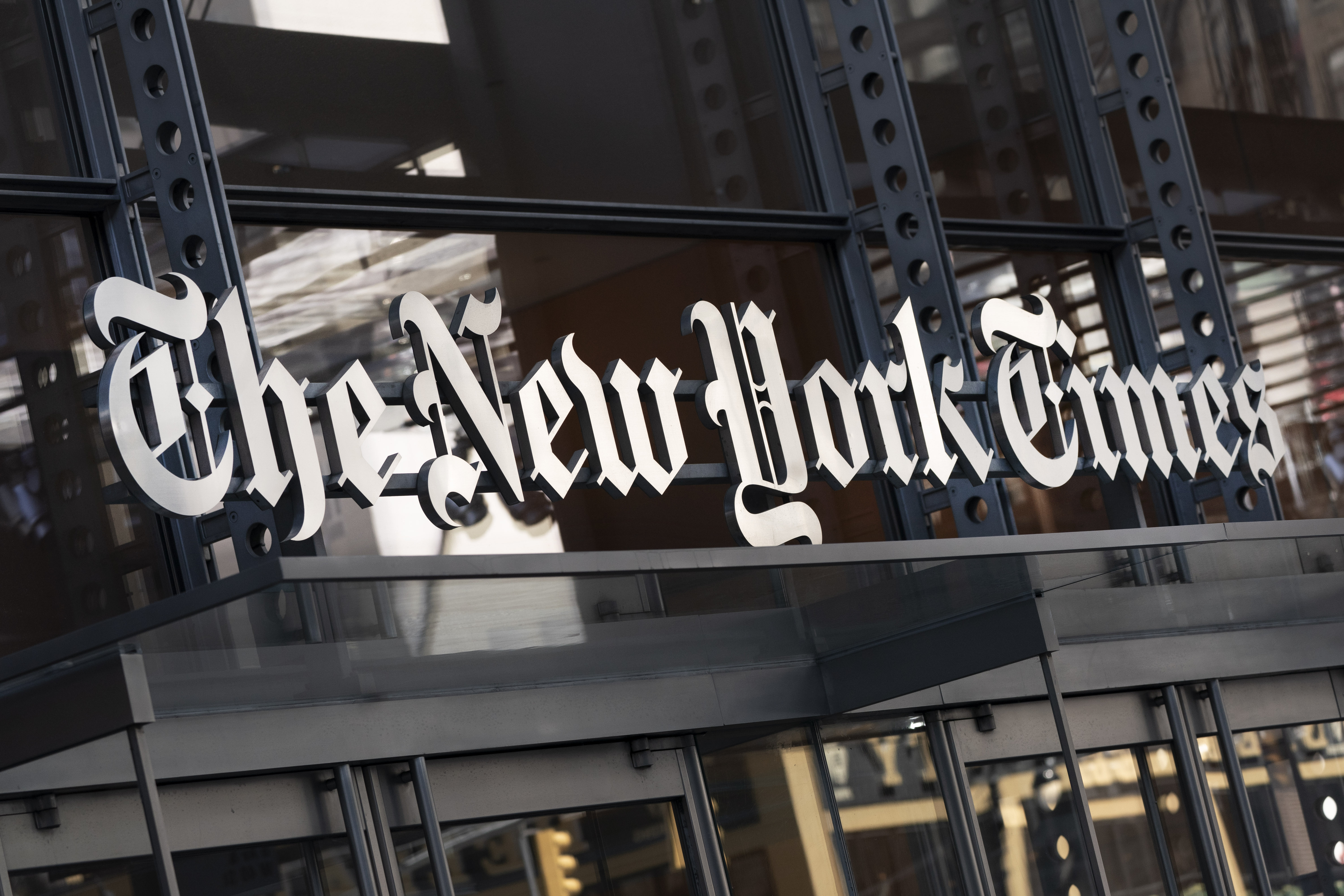 FILE - A sign for The New York Times hangs above the entrance to its building in New York, May 6, 2021.