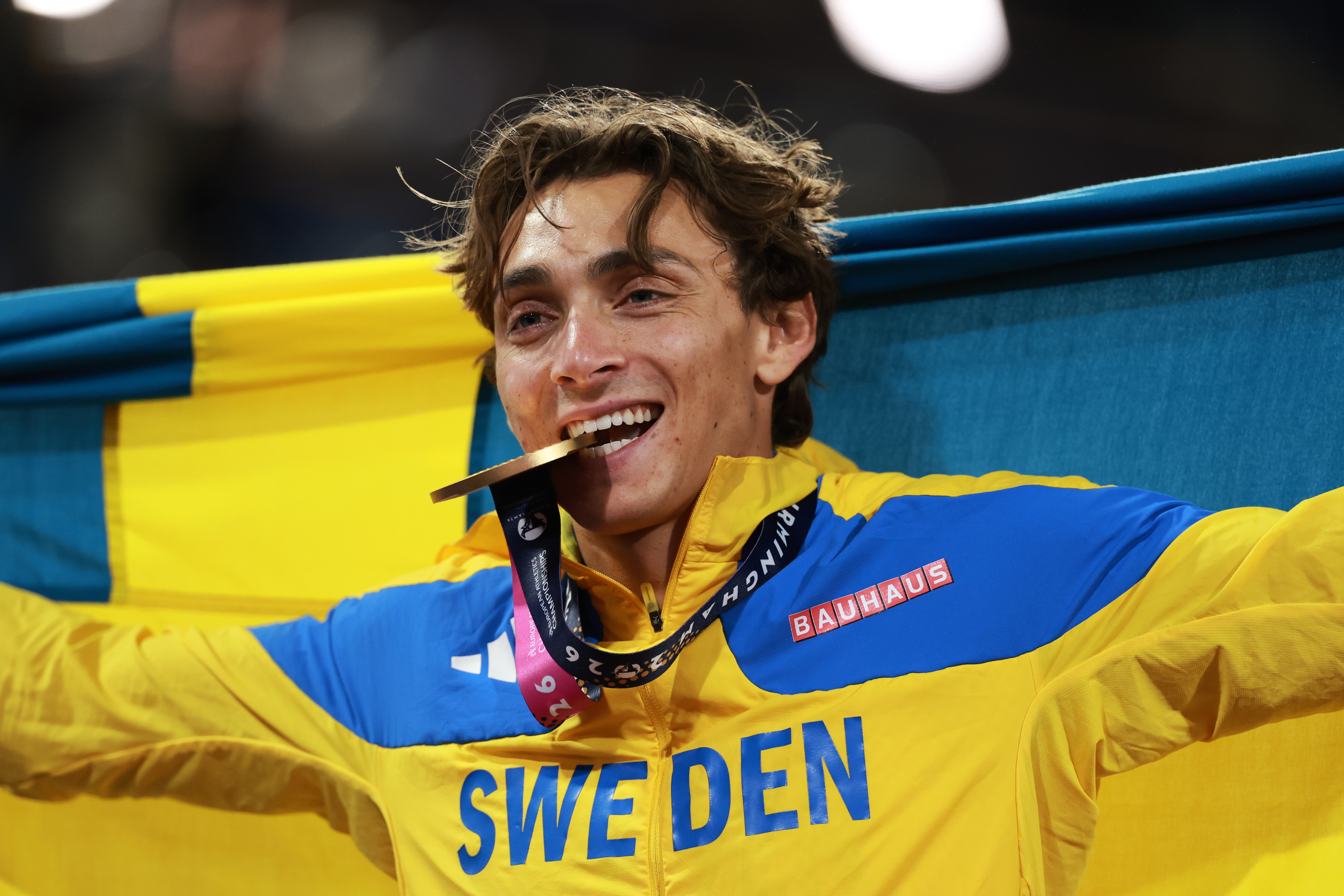 Sweden's Armand Duplantis bites his gold medal as he celebrates winning the men's pole vault final at the European Athletics Championships in Birmingham, England, Sunday, Aug. 16, 2026. 