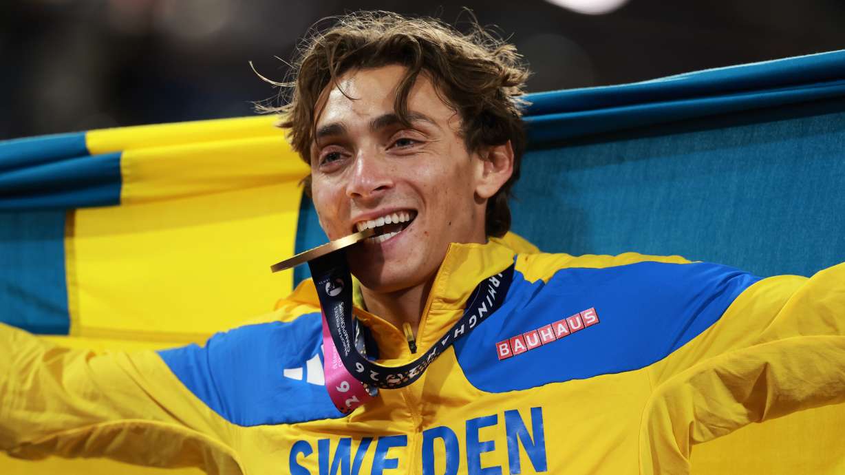 Sweden's Armand Duplantis bites his gold medal as he celebrates winning the men's pole vault final at the European Athletics Championships in Birmingham, England, Sunday, Aug. 16, 2026.