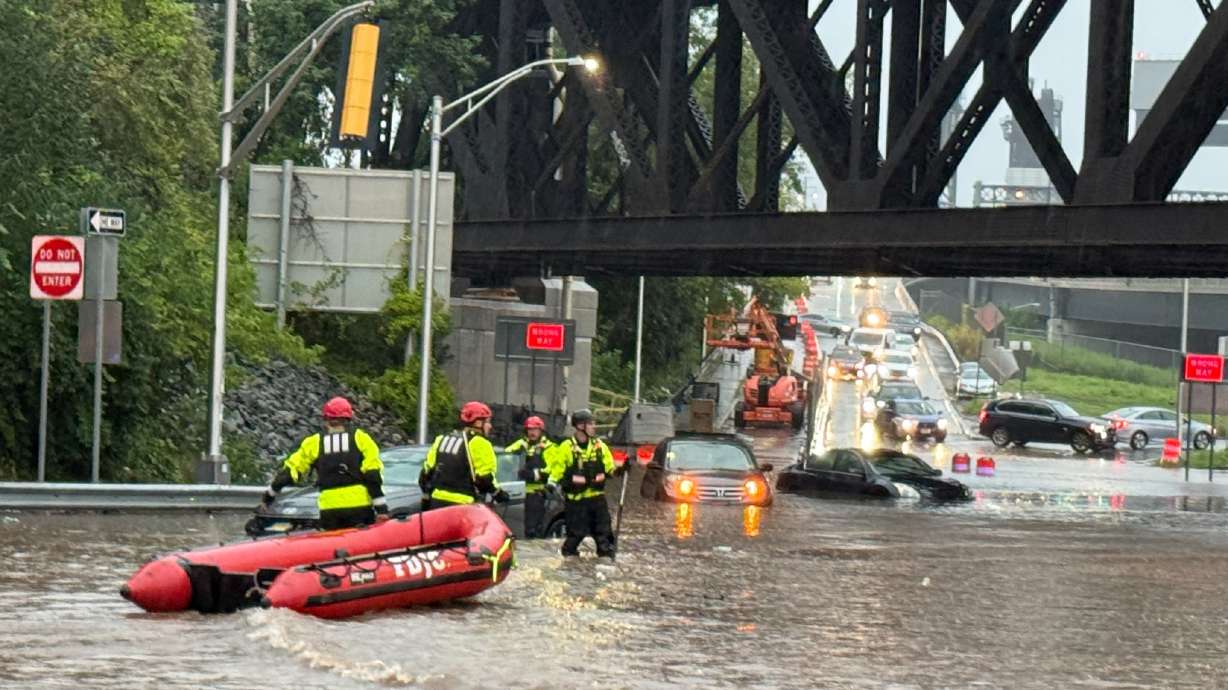 In this photo provided by the City of Jersey City, first responders try to rescue people stranded in a flooded street in Jersey City, N.J., Thursday, Aug. 20, 2026, after storms went through the area.