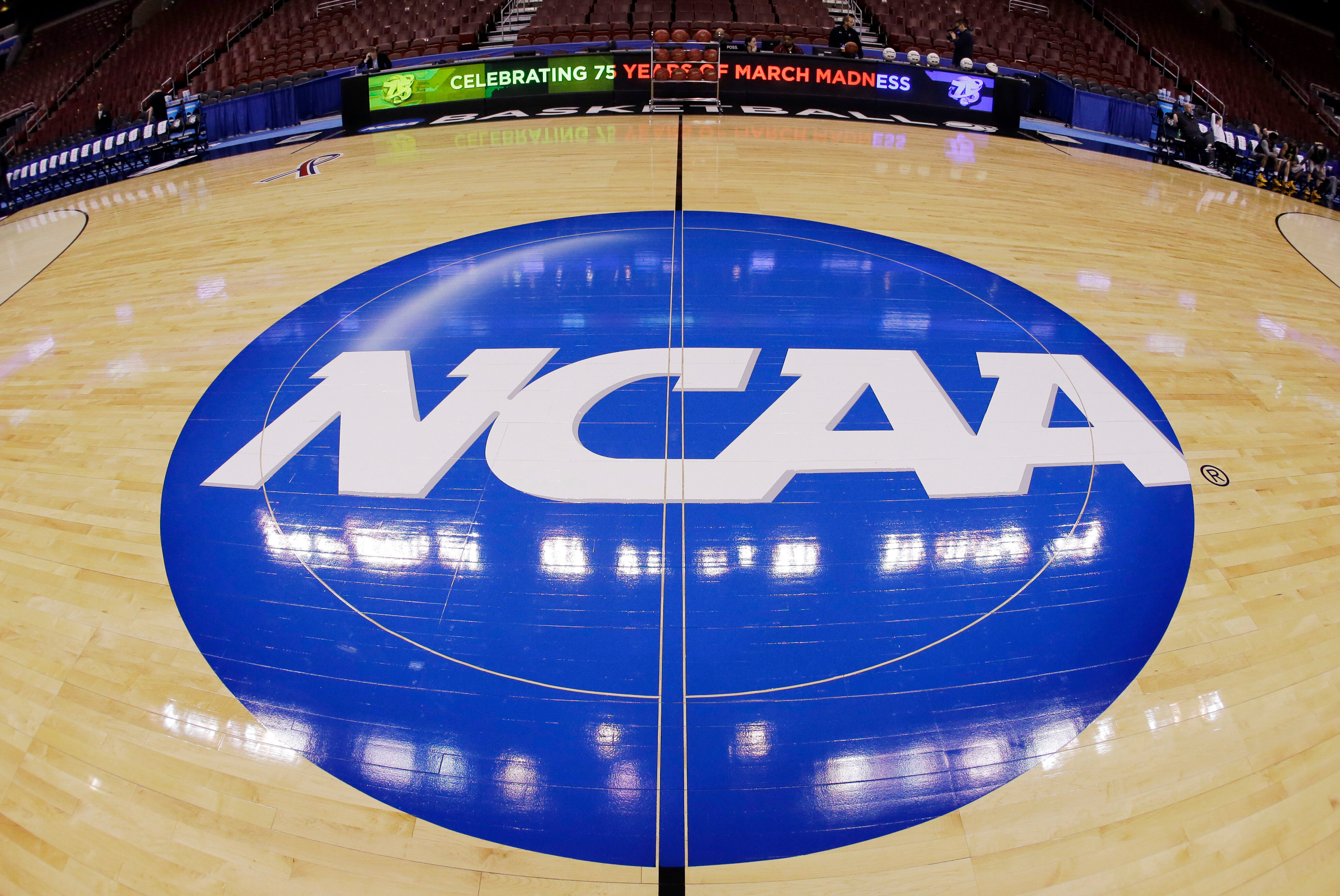 FILE - This photo taken with a fisheye lens shows the NCAA logo displayed at mid-court in Philadelphia, March 21, 2013. 