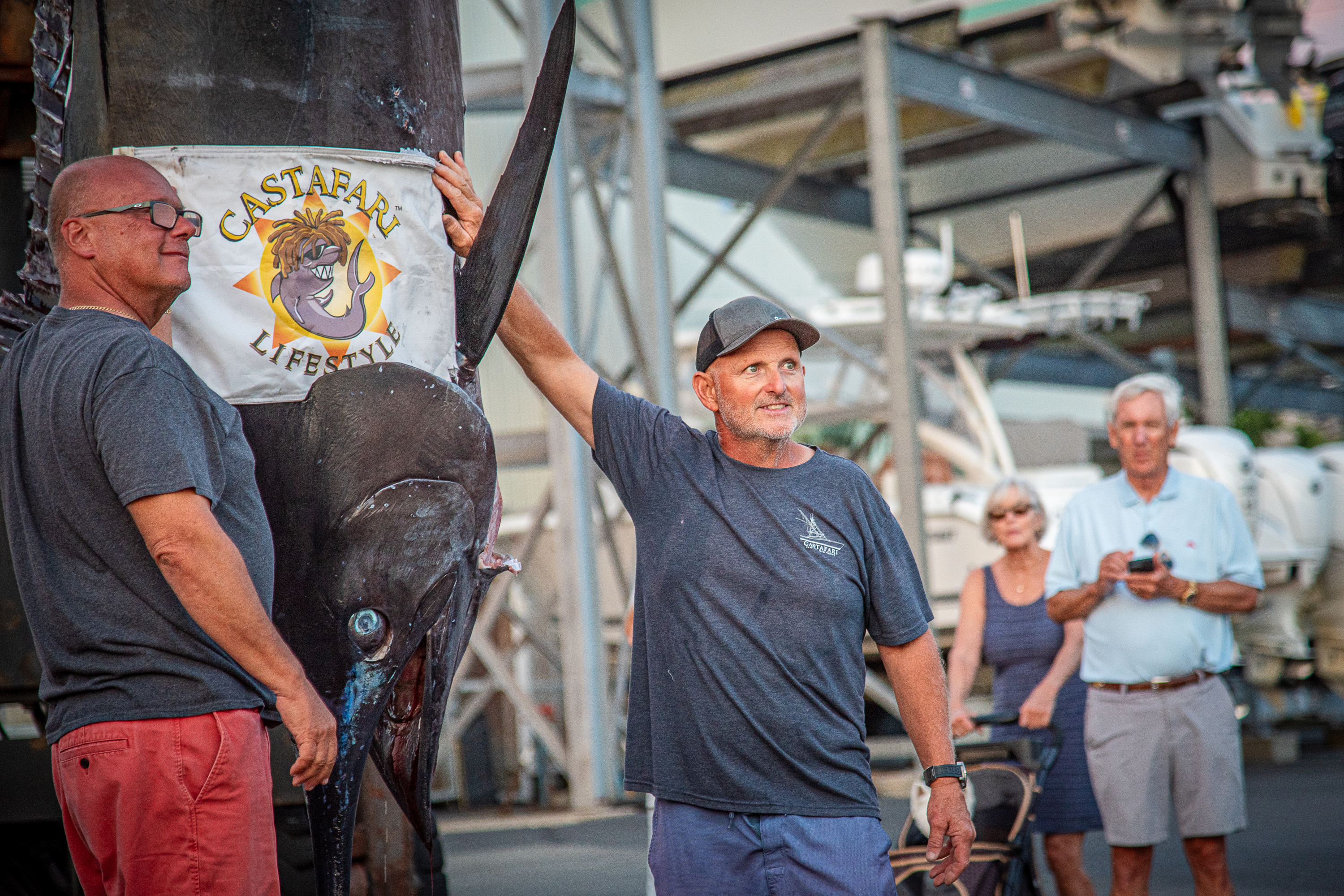 This photo provided by Jimmy Fee shows Walter Chapman, left, and Damon Sacco, captain of the Castafari, right, posing with an enormous blue marlin that they caught off the coast of Massachusetts, Wednesday, Aug. 19, 2026, in Falmouth, Mass. 