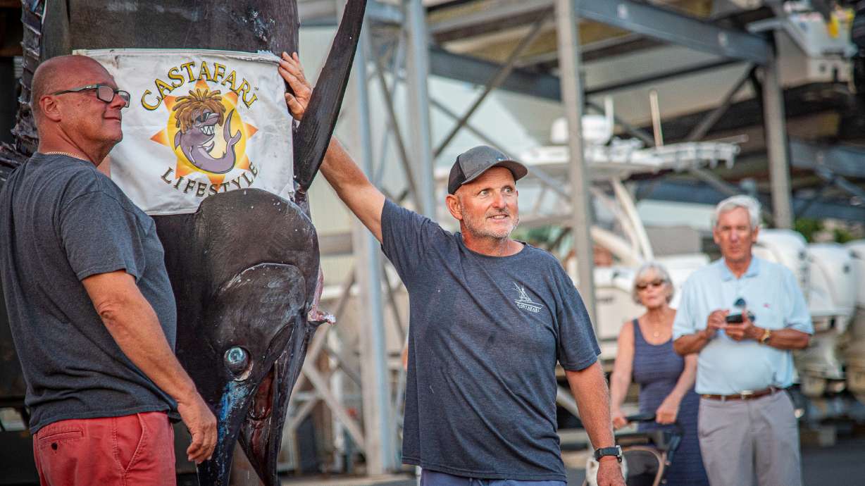 This photo provided by Jimmy Fee shows Walter Chapman, left, and Damon Sacco, captain of the Castafari, right, posing with an enormous blue marlin that they caught off the coast of Massachusetts, Wednesday, Aug. 19, 2026, in Falmouth, Mass.