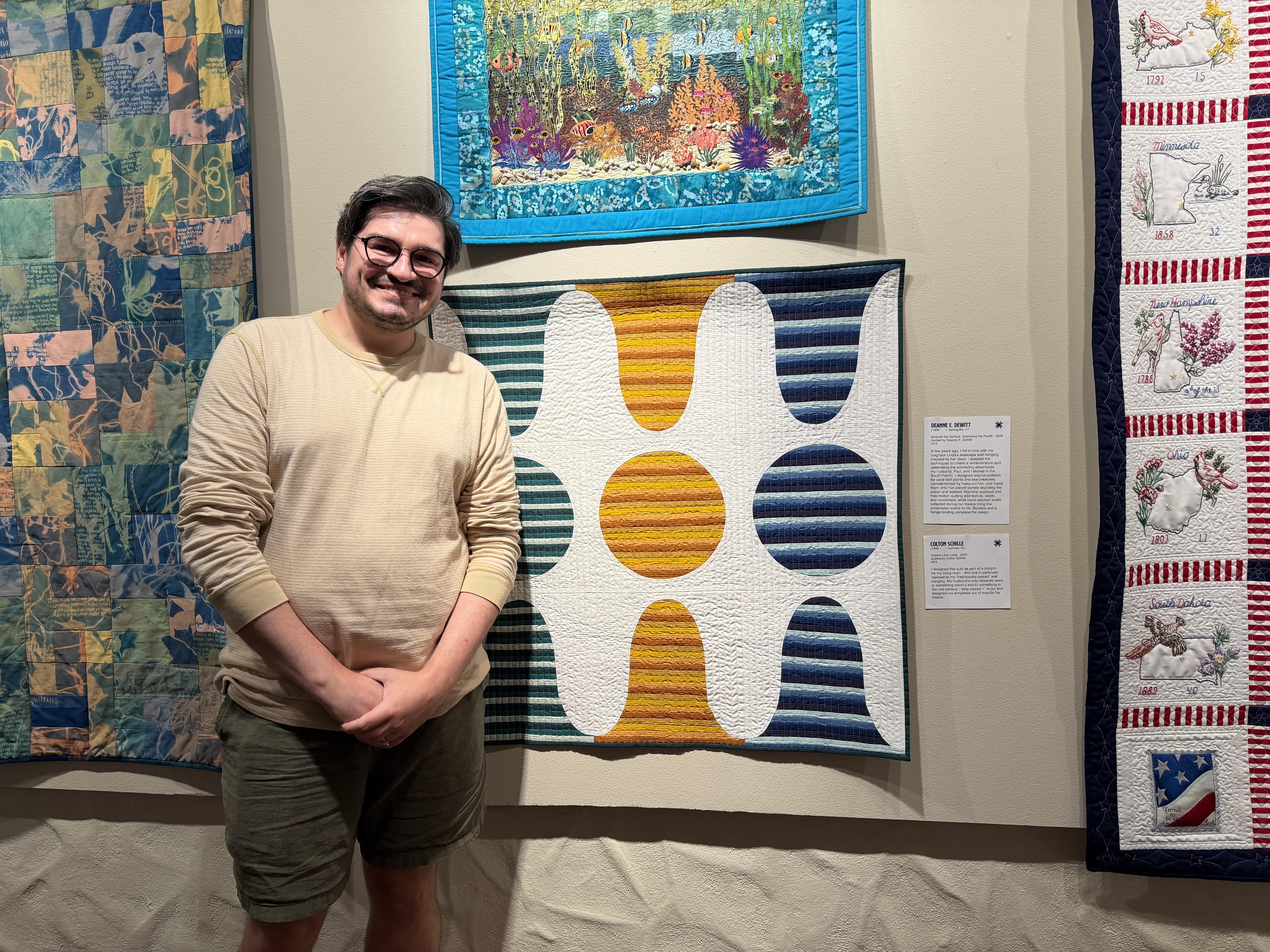 Colton Schille Smith stands in front of his quilt titled "Striped Lava Lamp," on Friday.