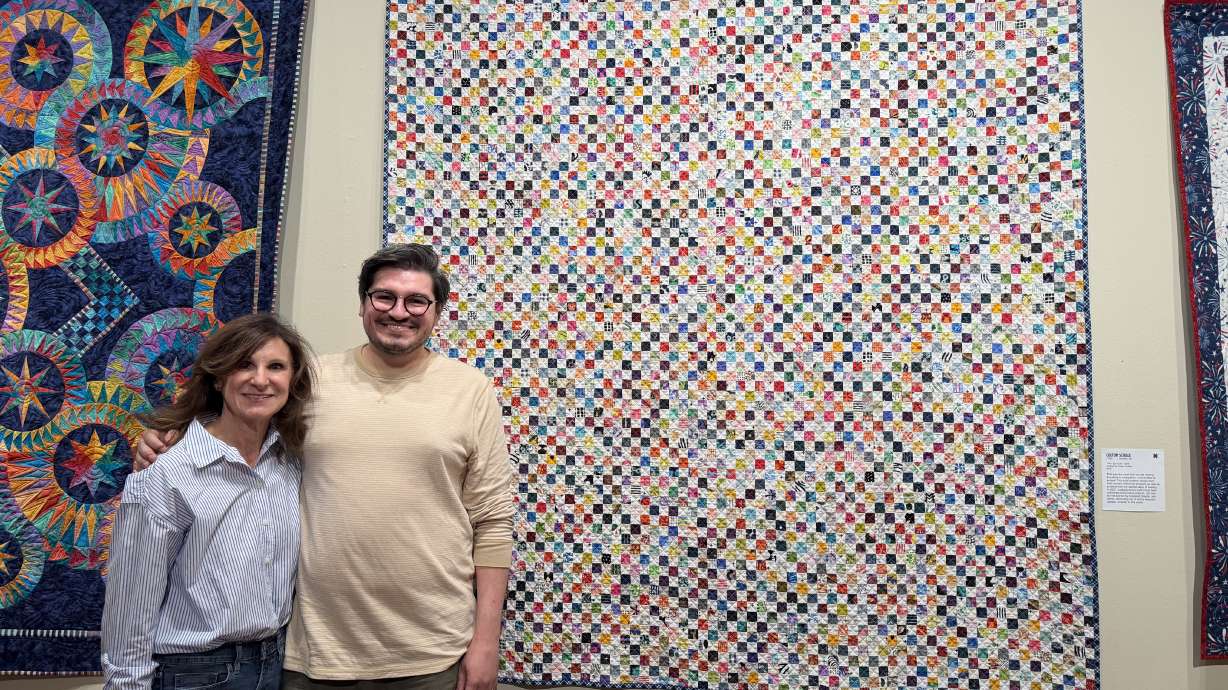 Jeri Schille and her son, Colton Schille Smith, stand in front of Schille Smith's quilt titled "The I Spy Quilt" on Friday, Aug. 21. Both are showing quilts at the Springville Museum of Art's annual quilt show.
