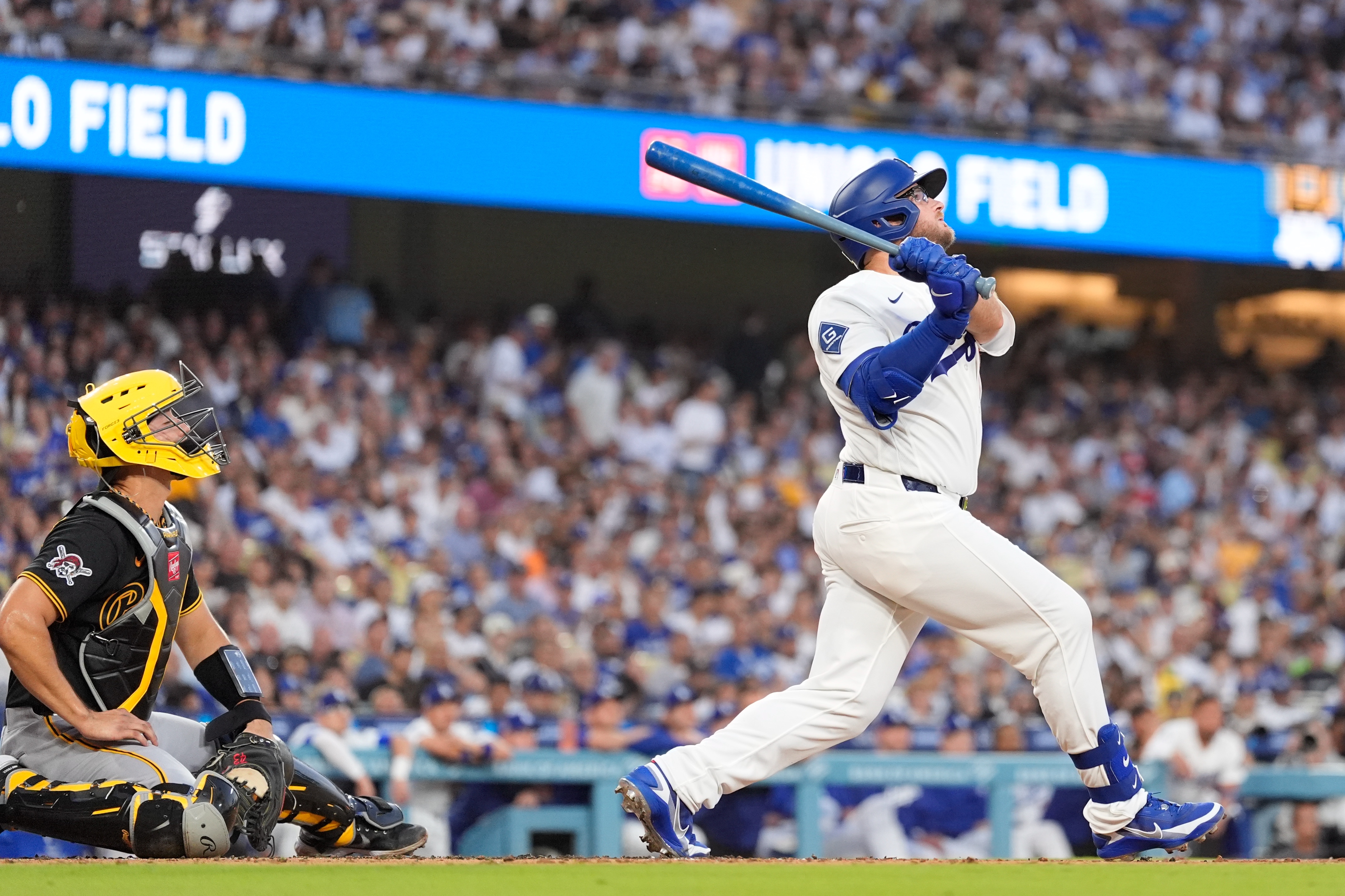 Los Angeles Dodgers' Max Muncy, right, hits a two-run home run as Pittsburgh Pirates catcher Rafael Flores Jr. watches during the first inning of a baseball game Friday, Aug. 21, 2026, in Los Angeles. 