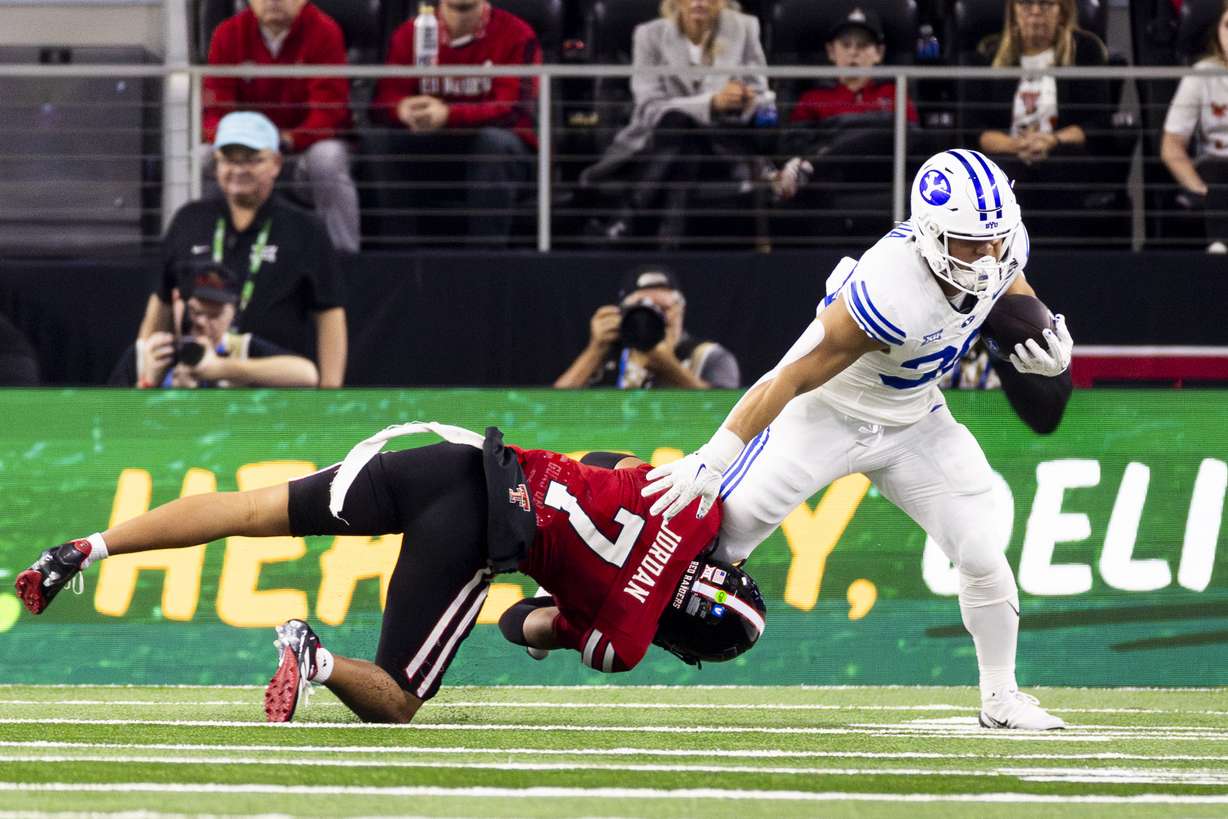 BYU running back Sione Moa (30) is downed by Texas Tech Red Raiders defensive back Brenden Jordan (7) during the Big 12 championship game held at AT&T Stadium in Arlington, Texas, on Saturday, Dec. 6, 2025.