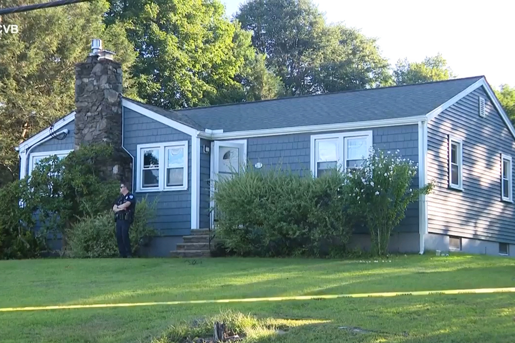 This screen grab made from video provided by WCVB-TV shows a police officer standing guard over a home in Worcester, Mass., Tuesday, Aug. 18, 2026. 