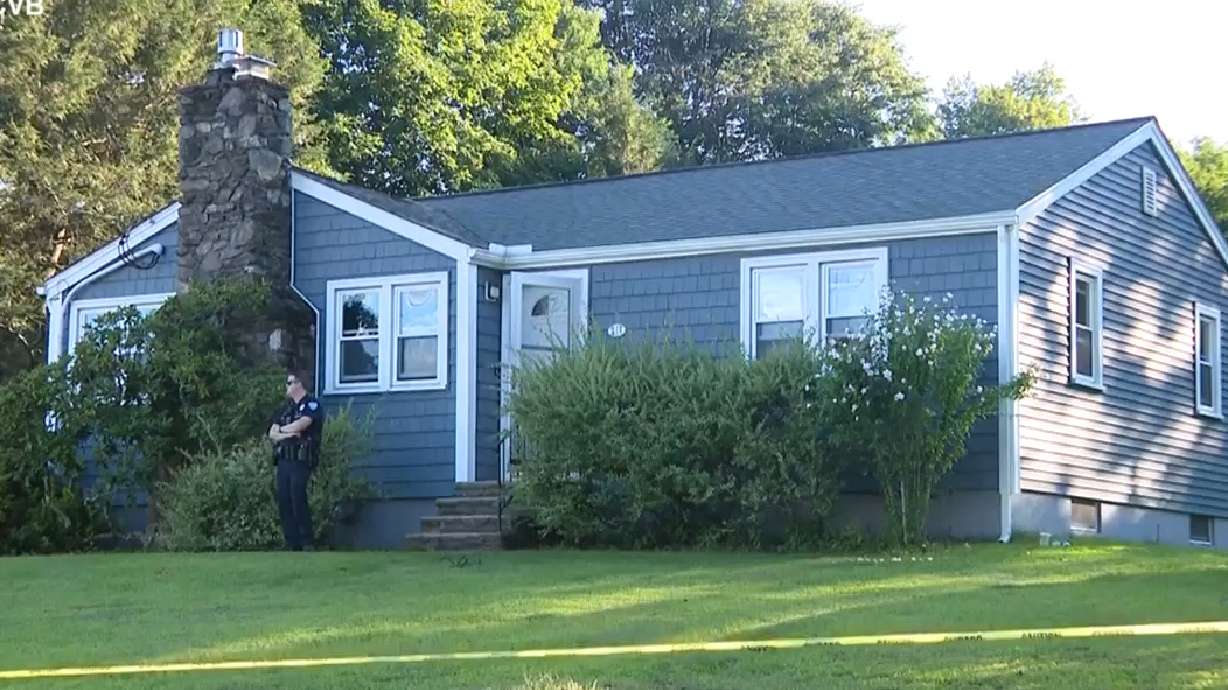 This screen grab made from video provided by WCVB-TV shows a police officer standing guard over a home in Worcester, Mass., Tuesday, Aug. 18, 2026.