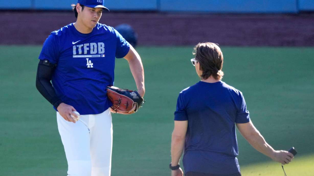 Los Angeles Dodgers' Shohei Ohtani warms up with a trainer prior to a baseball game against the Pittsburgh Pirates, Friday, Aug. 21, 2026, in Los Angeles.