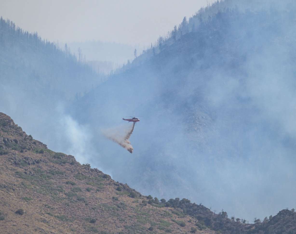 A helipoter makes a drop on the Monroe Canyon fire on Aug. 5, 2025.