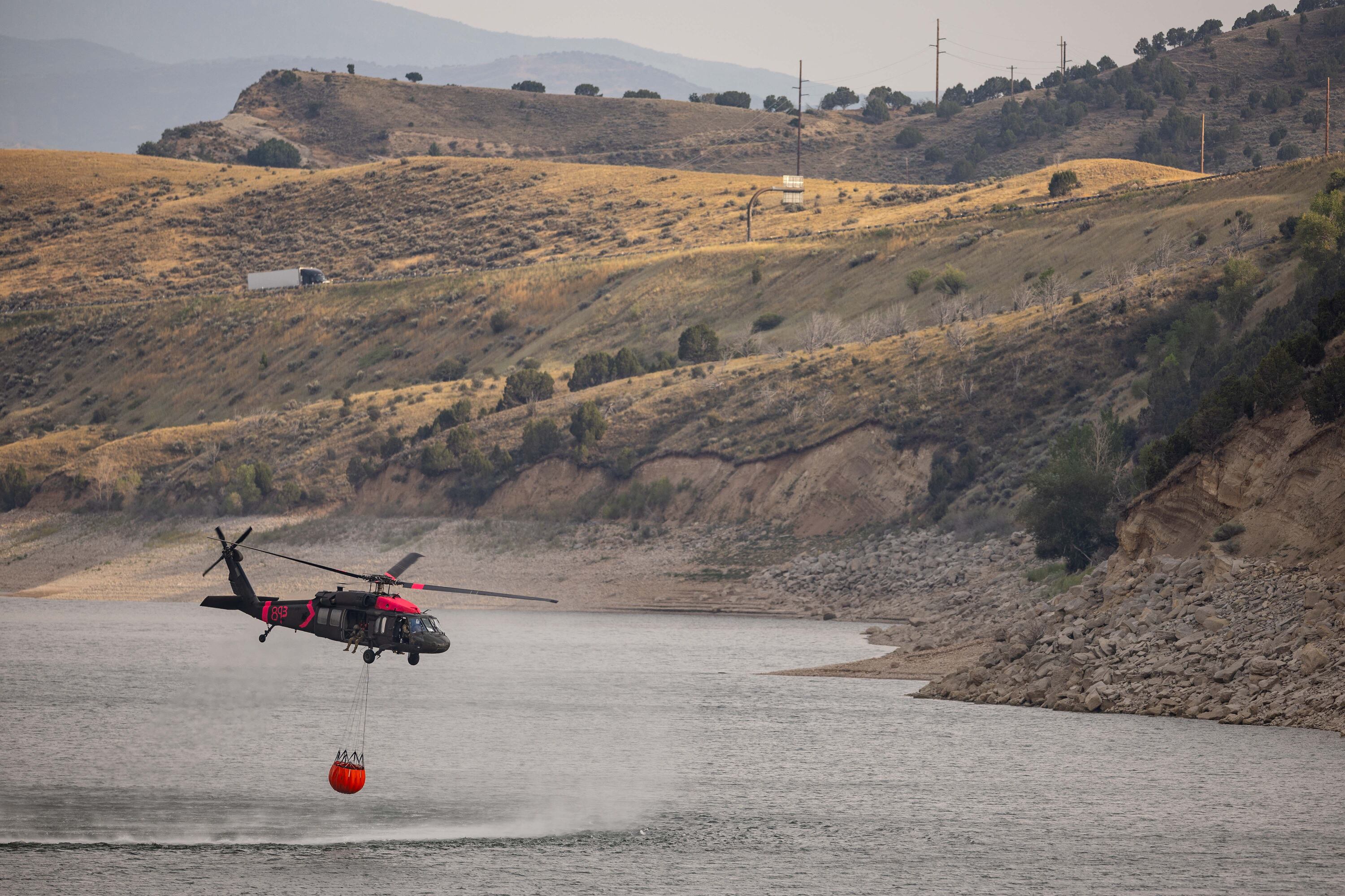 A helicopter begins its return trip to a wildfire in Rocky Canyon near Henefer after refilling its bucket at Echo Reservoir on Aug. 10.