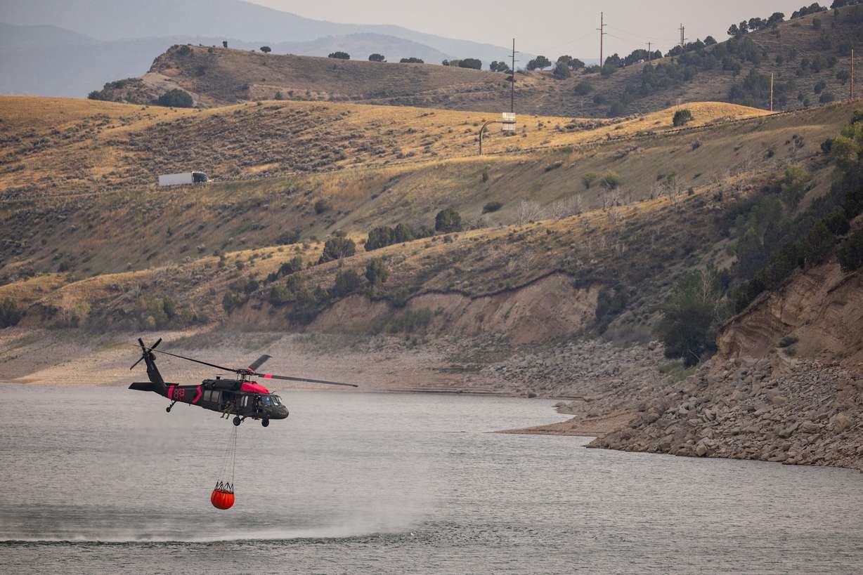 A helicopter begins its return trip to a wildfire in Rocky Canyon near Henefer after refilling its bucket at Echo Reservoir on Aug. 10.